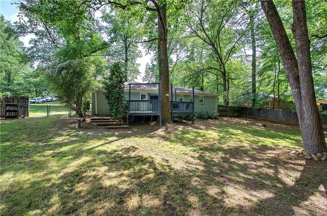 view of yard with a fenced backyard and a wooden deck