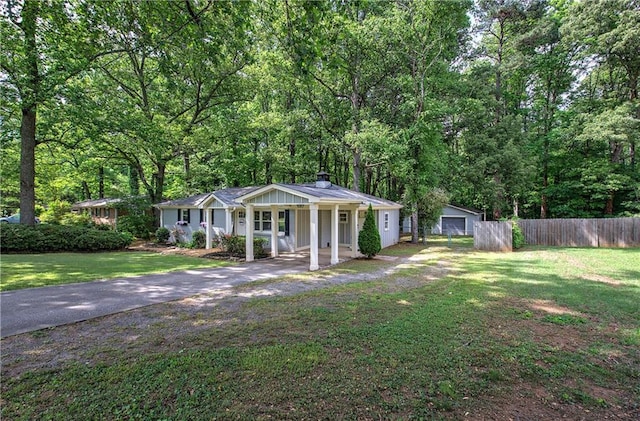 view of front of home featuring covered porch, fence, a chimney, and a front yard
