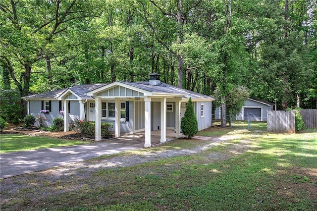 view of front of property featuring a porch, fence, driveway, and a front yard