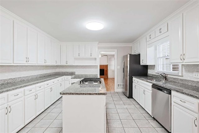 kitchen featuring a center island, white cabinets, stone countertops, and appliances with stainless steel finishes