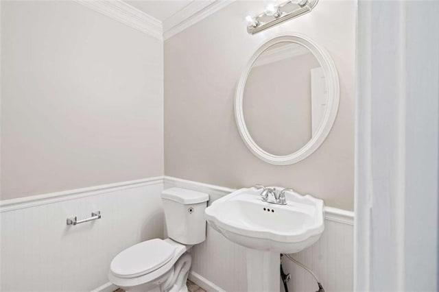 bathroom with ornamental molding and toilet