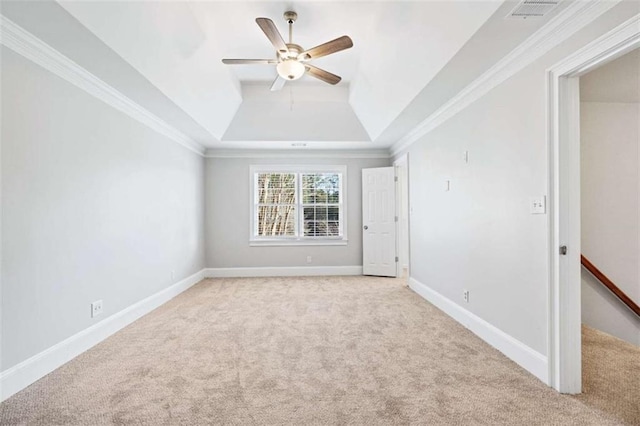 carpeted empty room with ceiling fan, ornamental molding, and a tray ceiling