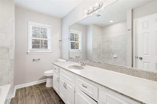 bathroom with walk in shower, hardwood / wood-style floors, vanity, and toilet