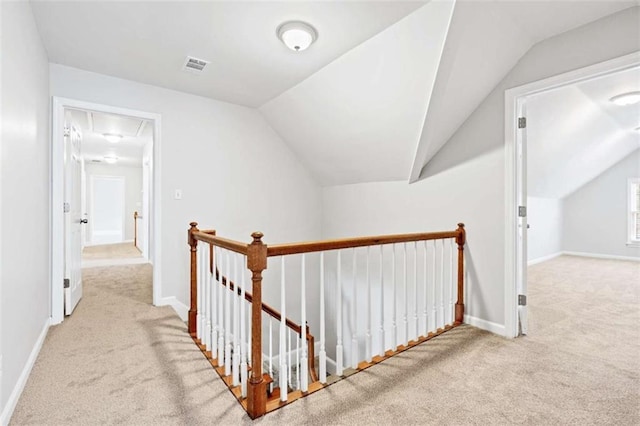 hall with light colored carpet and vaulted ceiling