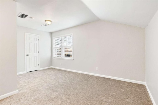 carpeted empty room with lofted ceiling