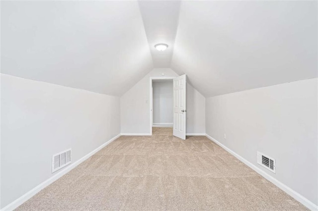 bonus room featuring light carpet and vaulted ceiling