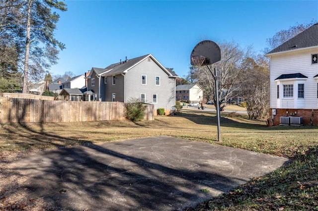 view of yard featuring basketball hoop and central AC unit