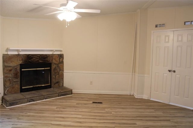 576 Nichols Rd, Pendergrass, GA 30567 - unfurnished living room featuring wood finished floors, a ceiling fan, a fireplace, and a decorative wall