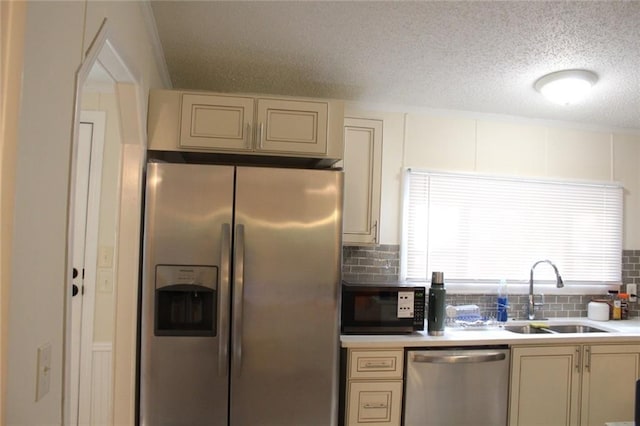 576 Nichols Rd, Pendergrass, GA 30567 - kitchen with stainless steel appliances, a sink, cream cabinetry, decorative backsplash, and a textured ceiling