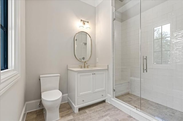 bathroom with a shower with door, vanity, hardwood / wood-style floors, and toilet