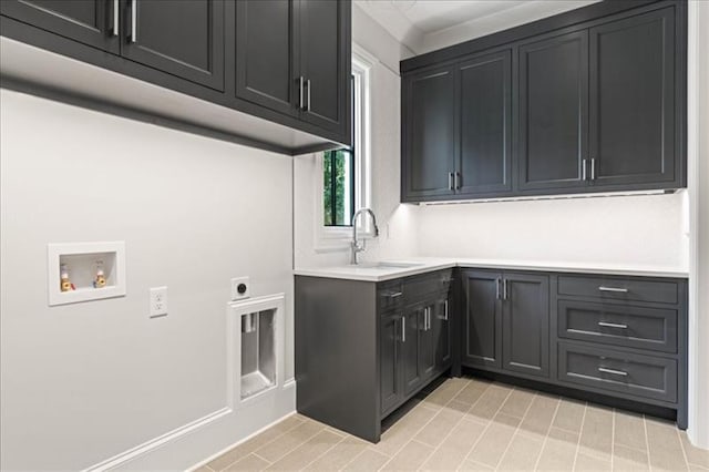 clothes washing area featuring electric dryer hookup, sink, hookup for a washing machine, and cabinets