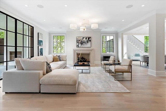 living room with plenty of natural light, light hardwood / wood-style flooring, and a notable chandelier