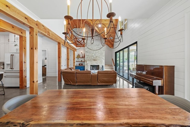 441 Pumpkinvine Rd, Acworth, GA 30101 - dining area featuring finished concrete floors, a fireplace, wood walls, and a chandelier