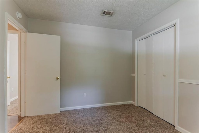 2783 Bicentennial Dr, Stone Mountain, GA 30087 - unfurnished bedroom with carpet flooring, a closet, and a textured ceiling