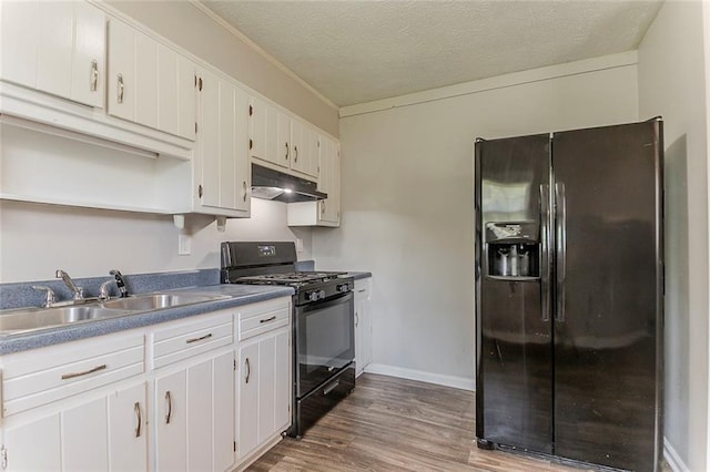 2783 Bicentennial Dr, Stone Mountain, GA 30087 - kitchen featuring refrigerator with ice dispenser, black gas range, under cabinet range hood, wood finished floors, and a textured ceiling