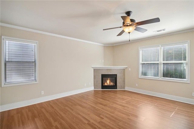 unfurnished living room with baseboards, ornamental molding, and wood finished floors