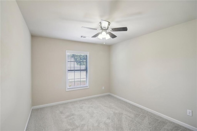 carpeted spare room featuring visible vents, ceiling fan, and baseboards