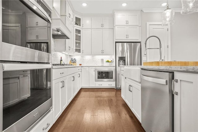 kitchen with pendant lighting, dark wood-style floors, glass insert cabinets, stainless steel appliances, and recessed lighting