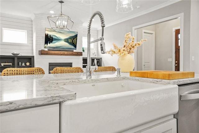 details with crown molding, a sink, a chandelier, and stainless steel dishwasher