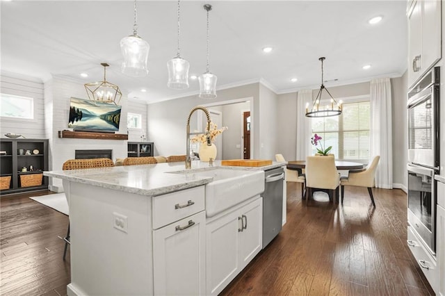 kitchen with recessed lighting, a sink, a large fireplace, and stainless steel appliances