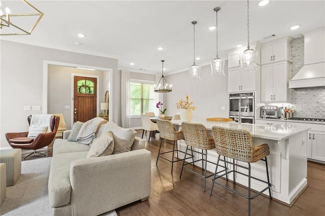 kitchen featuring decorative backsplash, a notable chandelier, double oven, and open floor plan