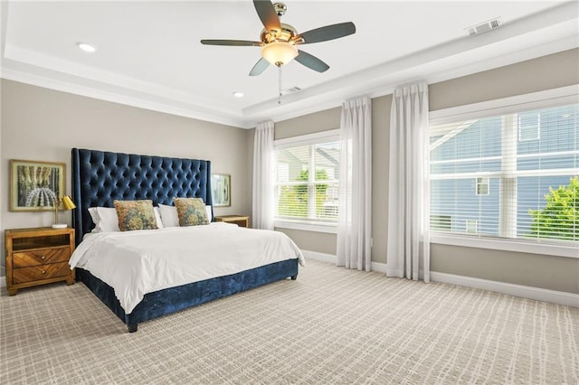bedroom with ceiling fan, visible vents, baseboards, a raised ceiling, and carpet floors