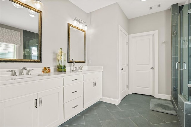 full bathroom featuring double vanity, visible vents, a shower stall, and a sink