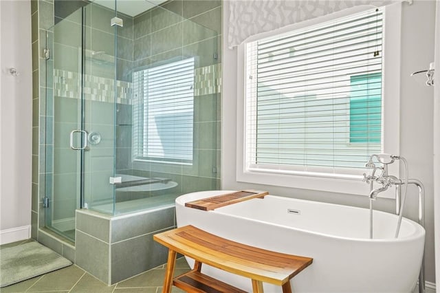 full bath featuring tile patterned floors, a shower stall, and a soaking tub