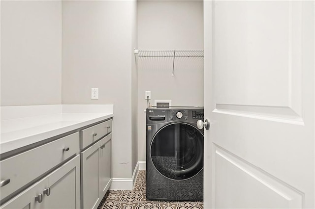 washroom with cabinet space, baseboards, washer / dryer, and tile patterned floors