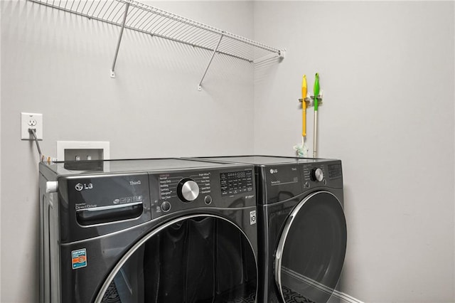 clothes washing area with separate washer and dryer and laundry area