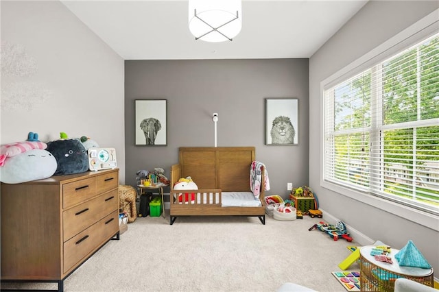bedroom with light colored carpet and multiple windows