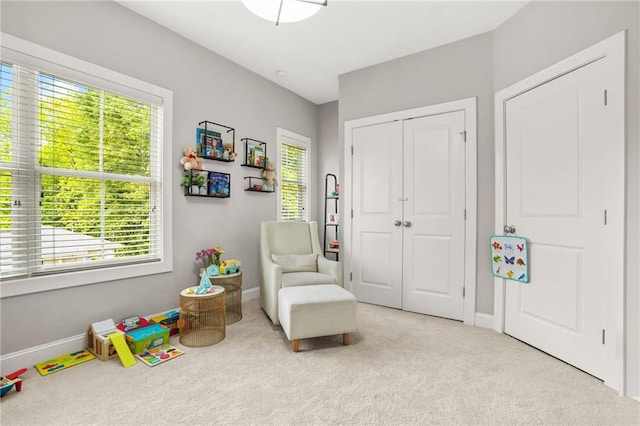 living area featuring carpet floors and baseboards