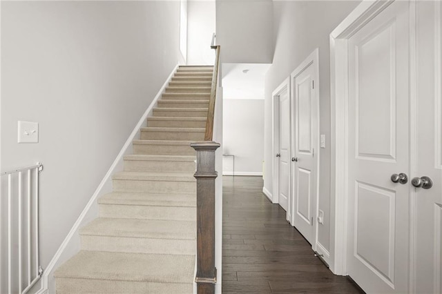 stairway with baseboards and hardwood / wood-style flooring