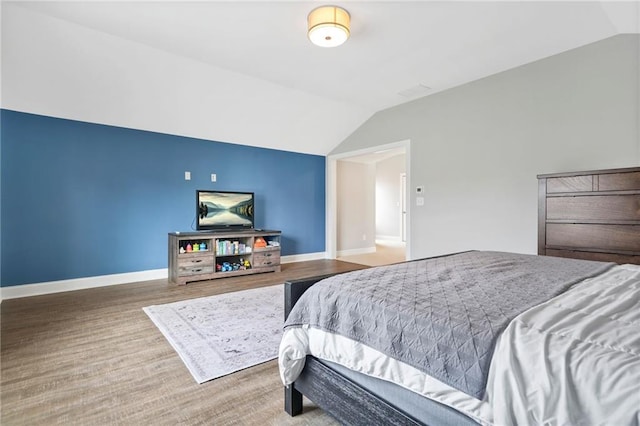 bedroom with baseboards and vaulted ceiling