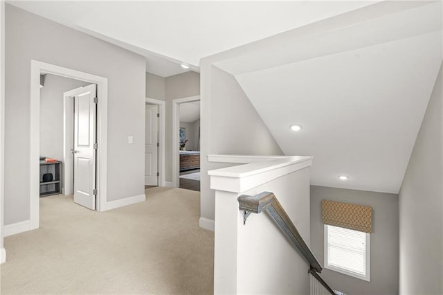 hall featuring light colored carpet, vaulted ceiling, baseboards, an upstairs landing, and recessed lighting