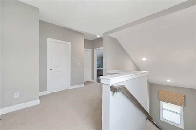 corridor featuring baseboards, light colored carpet, recessed lighting, and an upstairs landing