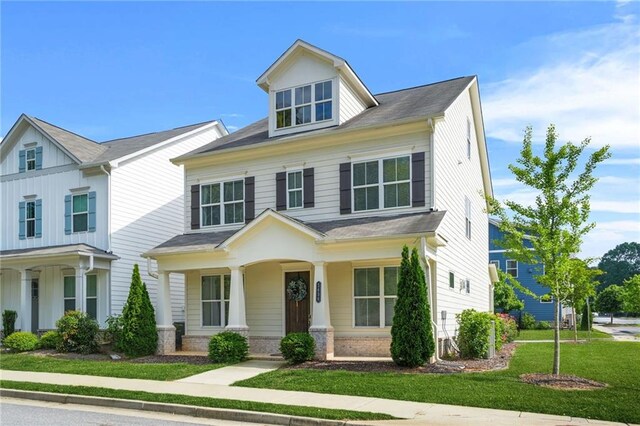 view of front of home with a porch and a front lawn