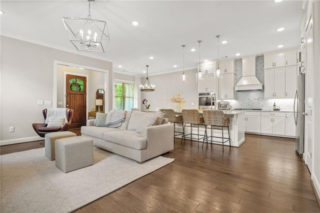 living room with recessed lighting, ornamental molding, dark wood finished floors, and a chandelier