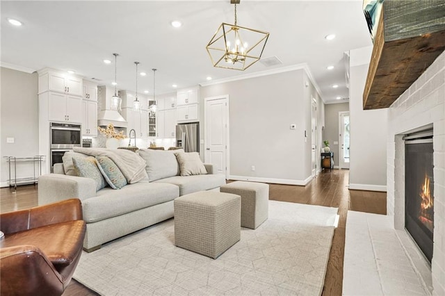 living area featuring crown molding, baseboards, a fireplace, and wood finished floors
