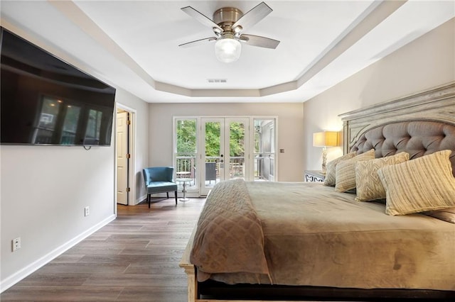 bedroom featuring visible vents, baseboards, access to outside, dark wood finished floors, and a tray ceiling