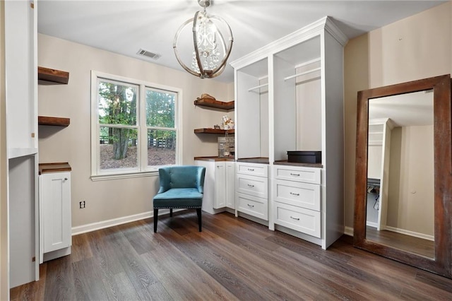 living area featuring dark wood-style floors, baseboards, a chandelier, and visible vents