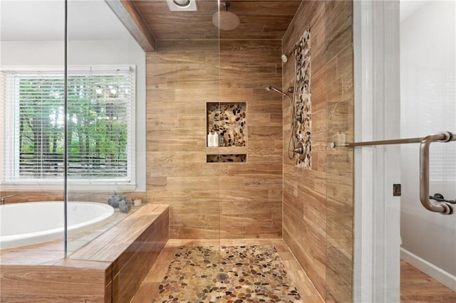 full bathroom with tiled shower and a bath