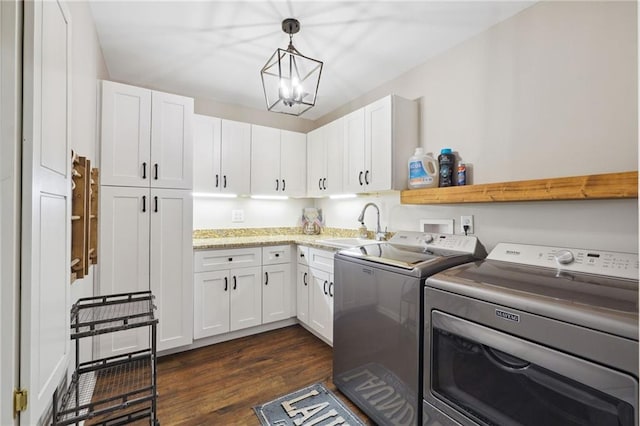 washroom with a chandelier, dark wood finished floors, a sink, cabinet space, and washing machine and dryer