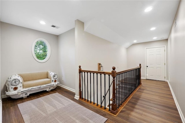 corridor with an upstairs landing, recessed lighting, baseboards, visible vents, and wood finished floors