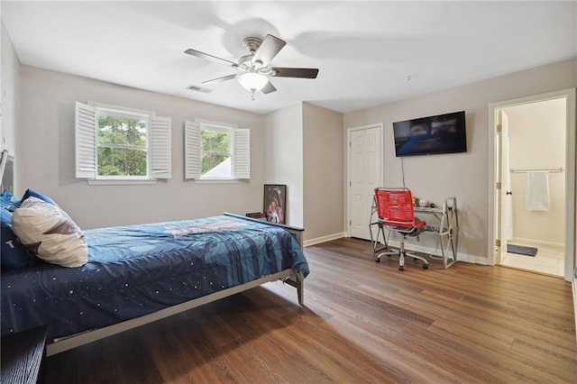 bedroom featuring baseboards, visible vents, wood finished floors, and ensuite bathroom