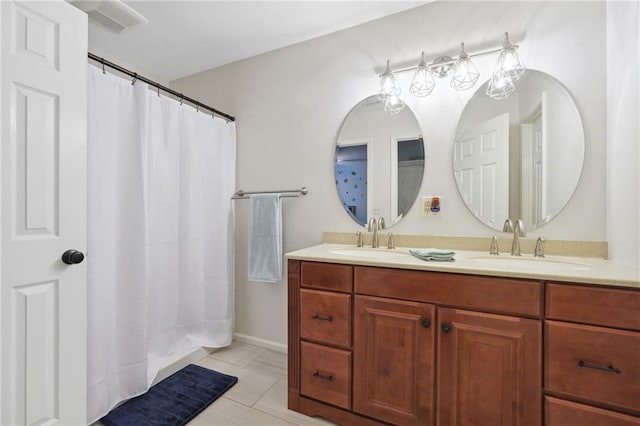 full bath featuring double vanity, a sink, and tile patterned flooring