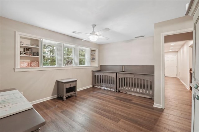 bedroom with wood finished floors, baseboards, ceiling fan, and visible vents