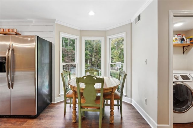 dining area featuring ornamental molding, dark wood-type flooring, baseboards, washer / dryer, and visible vents