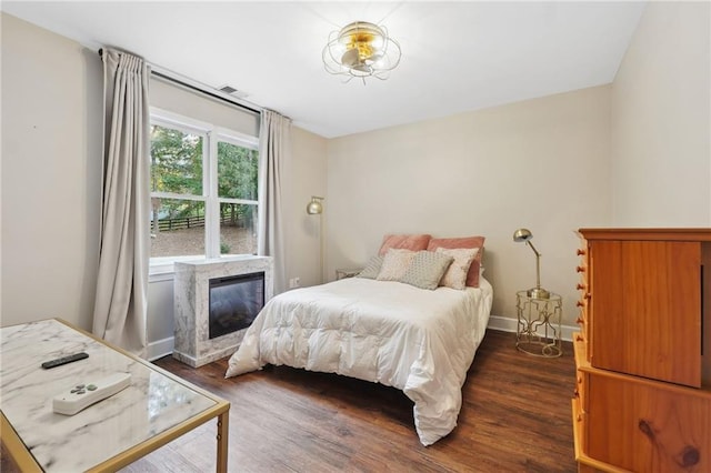 bedroom featuring dark wood-style floors, visible vents, and baseboards