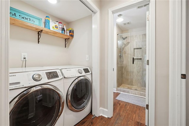 clothes washing area featuring laundry area, visible vents, separate washer and dryer, and dark wood finished floors